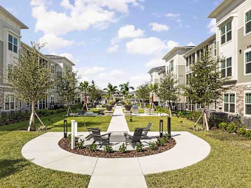 A sunny day at a residential area with apartment buildings and a park at Verity Luxury Apartments, Vero Beach, Florida