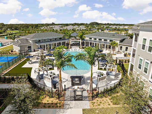 A large building with a pool in the middle of it at Verity Luxury Apartments, Vero Beach, 32960