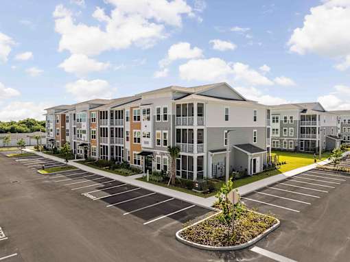 A large building with a parking lot in front of it at Verity Luxury Apartments, Vero Beach