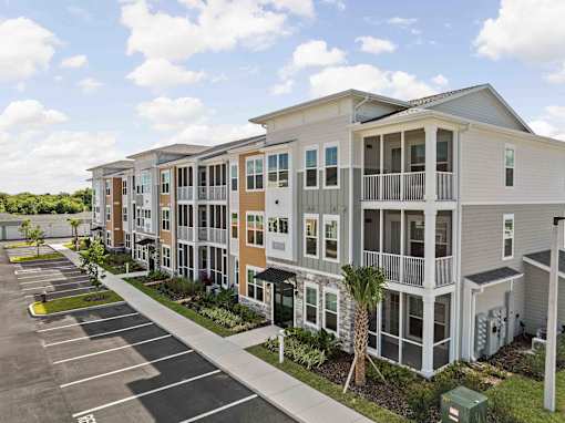 A row of modern townhouses with a parking lot in front at Verity Luxury Apartments, Vero Beach, FL