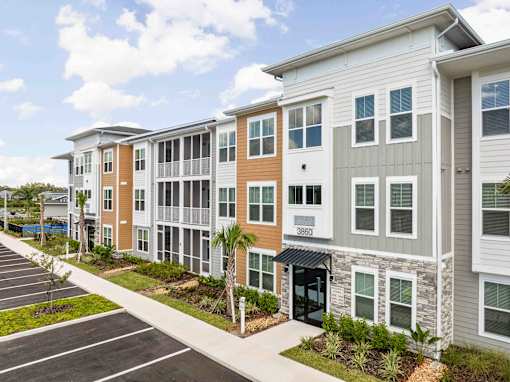 A row of modern townhouses with a parking lot in front at Verity Luxury Apartments, Vero Beach, 32960