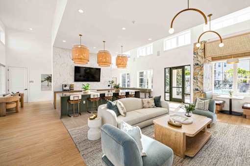 A modern living room with a bar area and a kitchen in the background at Verity Luxury Apartments, Vero Beach