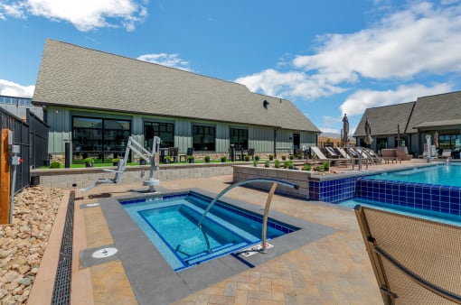 a resort style pool and hot tub with lounge chairs and a building in the background  at Upland Flats, Colorado Springs, CO