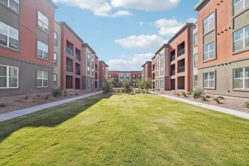 a grassy area in front of an apartment building at The Maddox Luxury Apartment Homes, Buckeye  