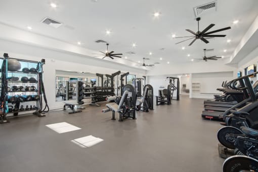 a gym with a lot of weights and exercise equipment at The Maddox Luxury Apartment Homes, Buckeye, AZ 85326  