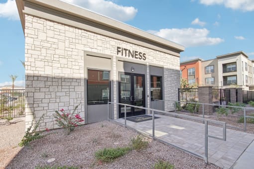 a fitness building with a glass door and a sign on the side of it at The Maddox Luxury Apartment Homes, Arizona  