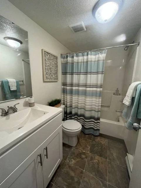 A bathroom with a toilet, sink, and shower.