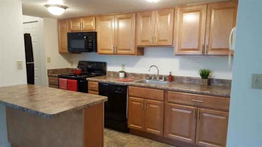 A kitchen with wooden cabinets and a granite countertop.