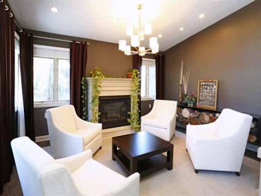 A living room with a fireplace and four chairs.