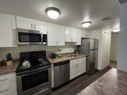 A kitchen with white cabinets and stainless steel appliances.