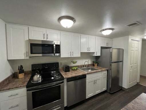 A kitchen with white cabinets and stainless steel appliances.