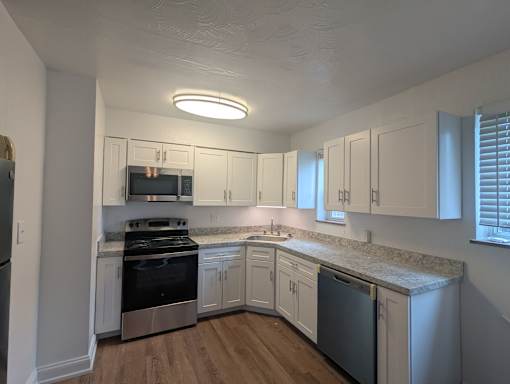 A kitchen with white cabinets and stainless steel appliances at Pacific Highlands Apartments, Natrona Heights, PA, 15065