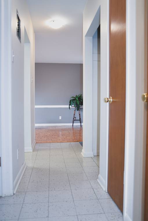 Bright hallway leading to living area with hardwood floors and neutral wall colours at 359 Edison.