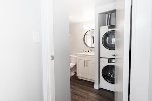 a white bathroom with a washer and dryer in it