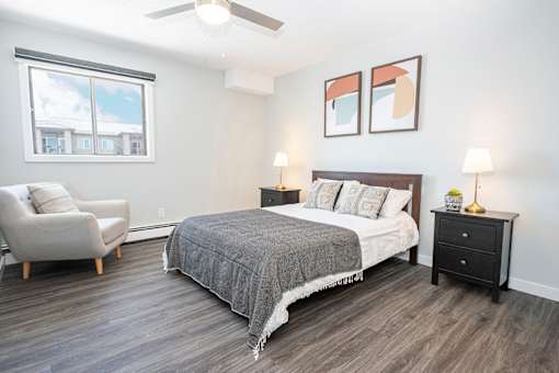 a bedroom with a bed and a chair and a window