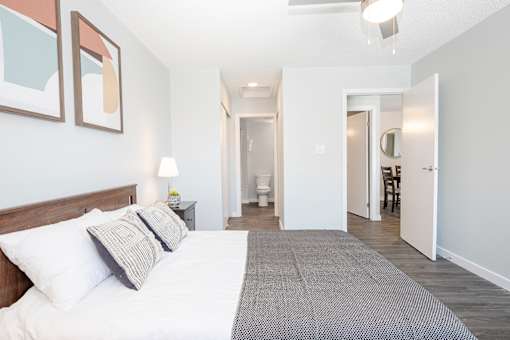 a bedroom with a bed and a view of a bathroom and a hallway