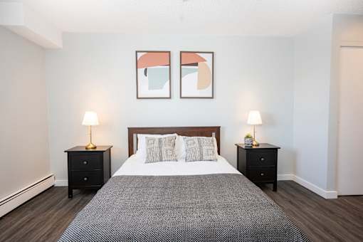 a bedroom with a large bed and two night stands with lamps