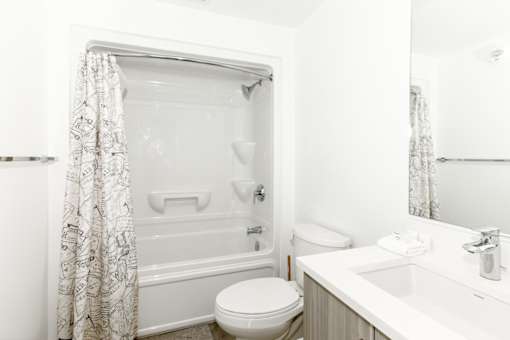 A white bathroom with a toilet, sink, and bathtub.