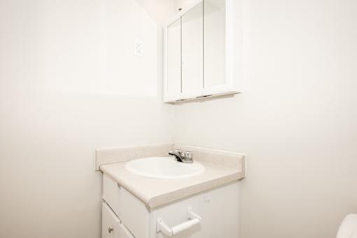 A white bathroom sink with a cabinet above it.