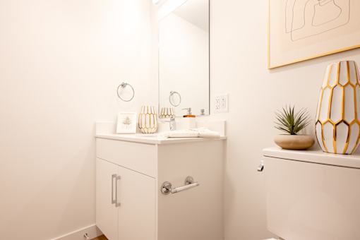 A bathroom with a white cabinet and a white toilet.