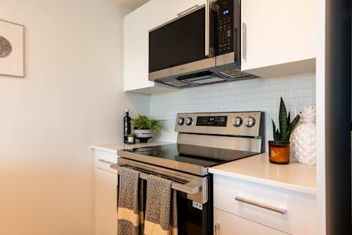 A modern kitchen with a stainless steel oven and microwave above it.