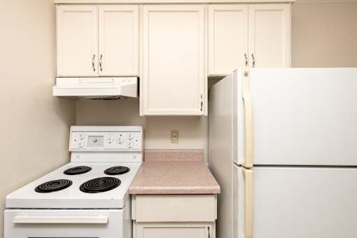 A kitchen with a white stove and a white refrigerator.