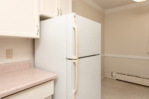 A white refrigerator with a white door stands in a kitchen.