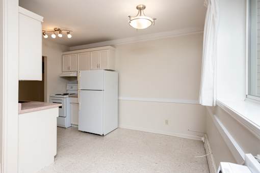 A kitchen with white appliances and cabinets.