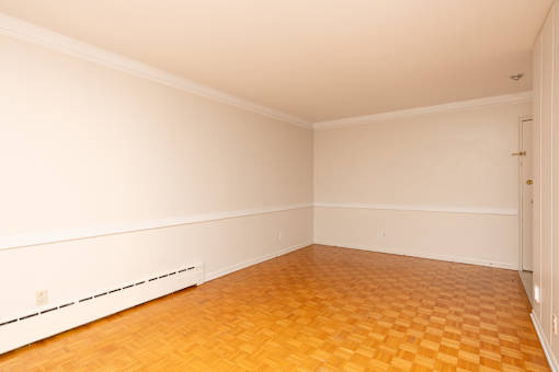 Empty room with wooden floor and white walls.