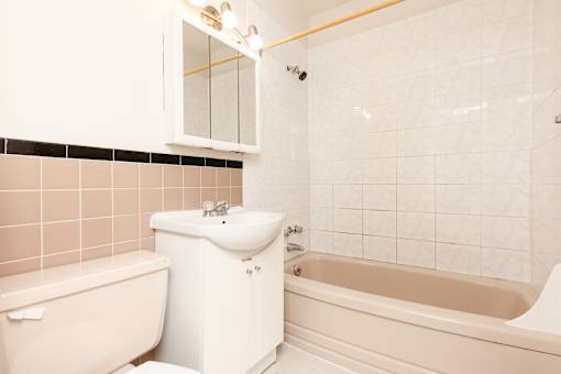 A white bathroom with a tub, toilet, and sink.