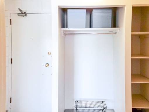 Entryway with a built-in closet and shelving for extra storage at 1025 Munroe Apartments.
