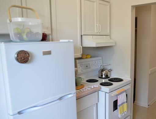 White fridge and stove setup with compact countertops in 359 Edison’s kitchen.