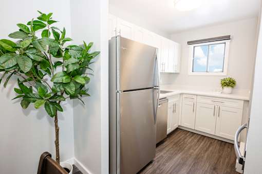 a kitchen with white cabinets and a stainless steel refrigerator