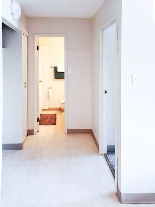 Well-lit hallway leading to the bathroom and bedroom in a one-bedroom unit at 1025 Munroe Apartments.