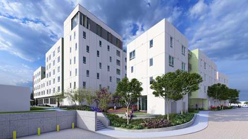 A modern white building with a courtyard in front.