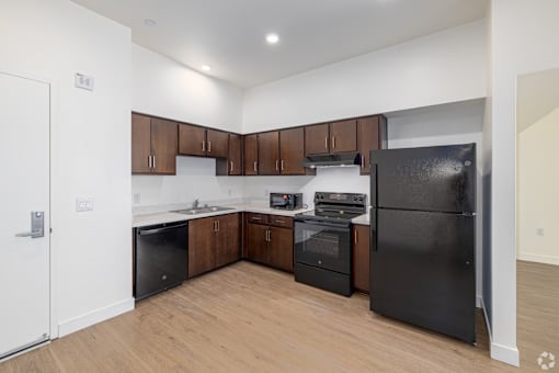 A kitchen with black appliances and wooden cabinets.