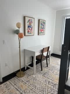 A white table with a chair and a floor lamp in a room.