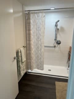A bathroom with a shower curtain and a shower head.