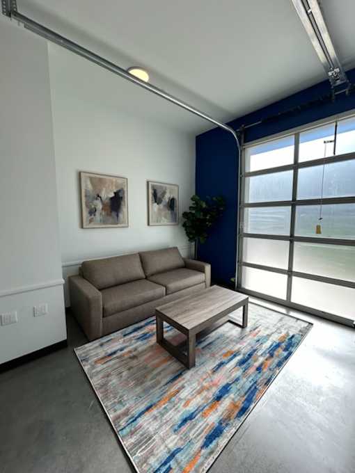 A living room with a couch, coffee table, and two pictures on the wall.