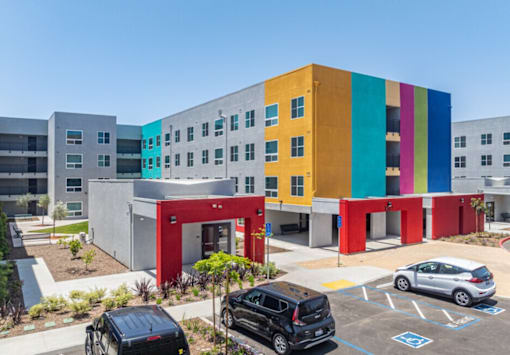 A colorful building with a parking lot in front.