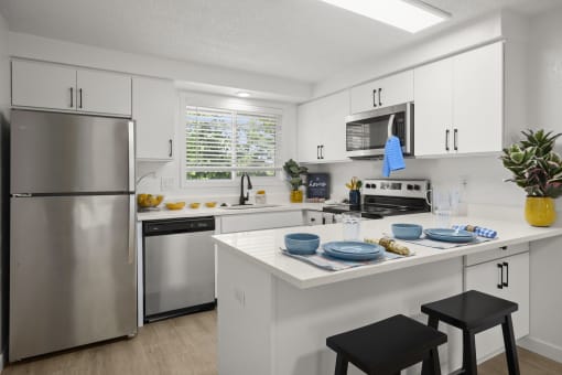 a kitchen with white cabinets and stainless steel appliances at Chalet, Springfield