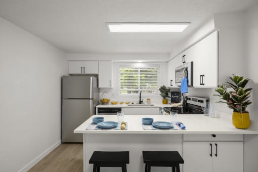 a kitchen with white cabinets and a white island with two black stools in front of it at Chalet, Springfield, 97477