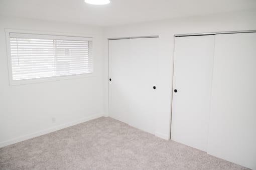 a small bedroom with white walls and carpet at Chalet, Springfield, 97477