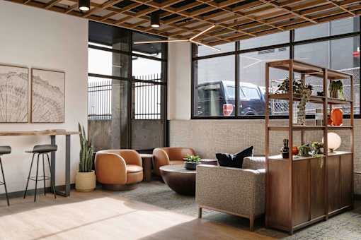 A room with a wooden ceiling and furniture including a sofa, chairs, and a table. at Elevation16 Apartments, Seattle, Washington