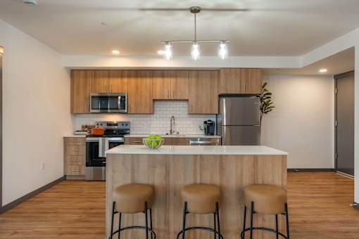 A kitchen with a bar stool in front of the counter at Elevation16 Apartments, Washington