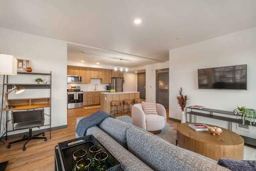 A modern living room with a grey sofa and a wooden coffee table at Elevation16 Apartments, Seattle, WA