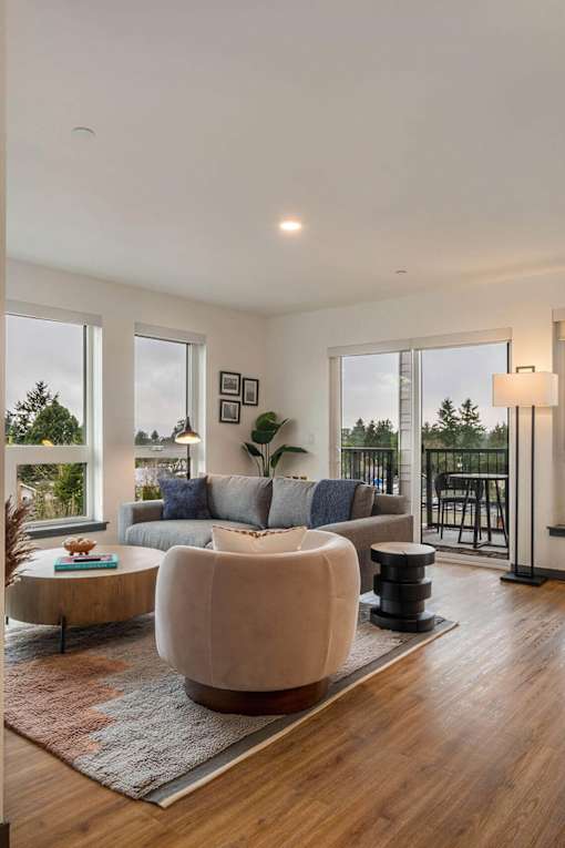 A modern living room with a large sectional sofa and a coffee table at Elevation16
