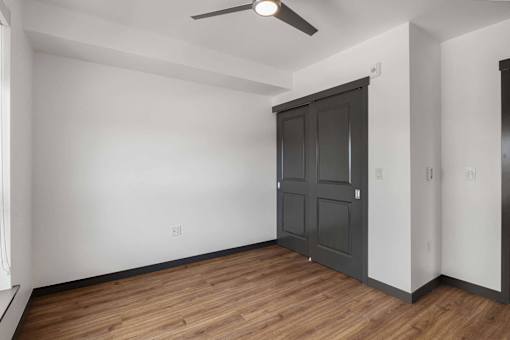 an empty living room with white walls and a black door at Elevation16 Apartments, Seattle