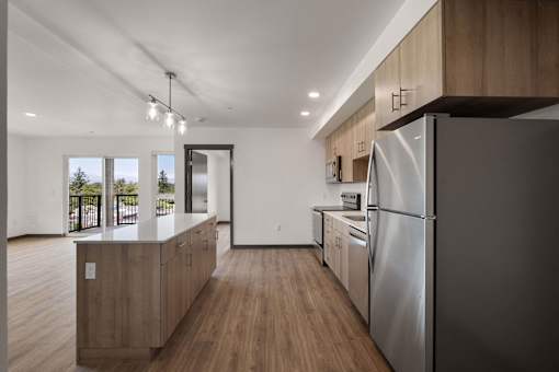 a large kitchen with wooden floors and stainless steel appliances at Elevation16 Apartments, Seattle, WA
