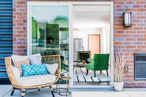 Cozy one-bedroom apartment patio accessible from the kitchen area through a sliding door. The outdoor space features a small seating area for relaxation or outdoor dining.
